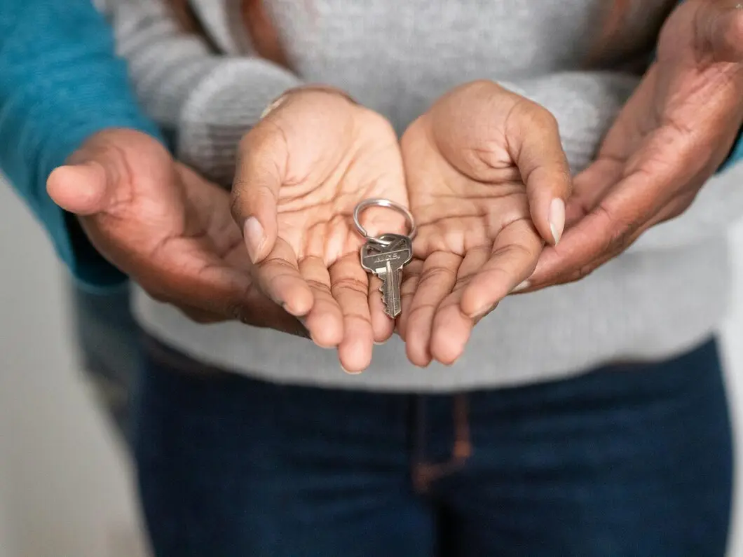 Agente immobiliare che consegna le chiavi a una coppia